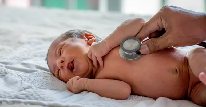 Soft blur of the doctor hands use stethoscope to check newborn baby health.